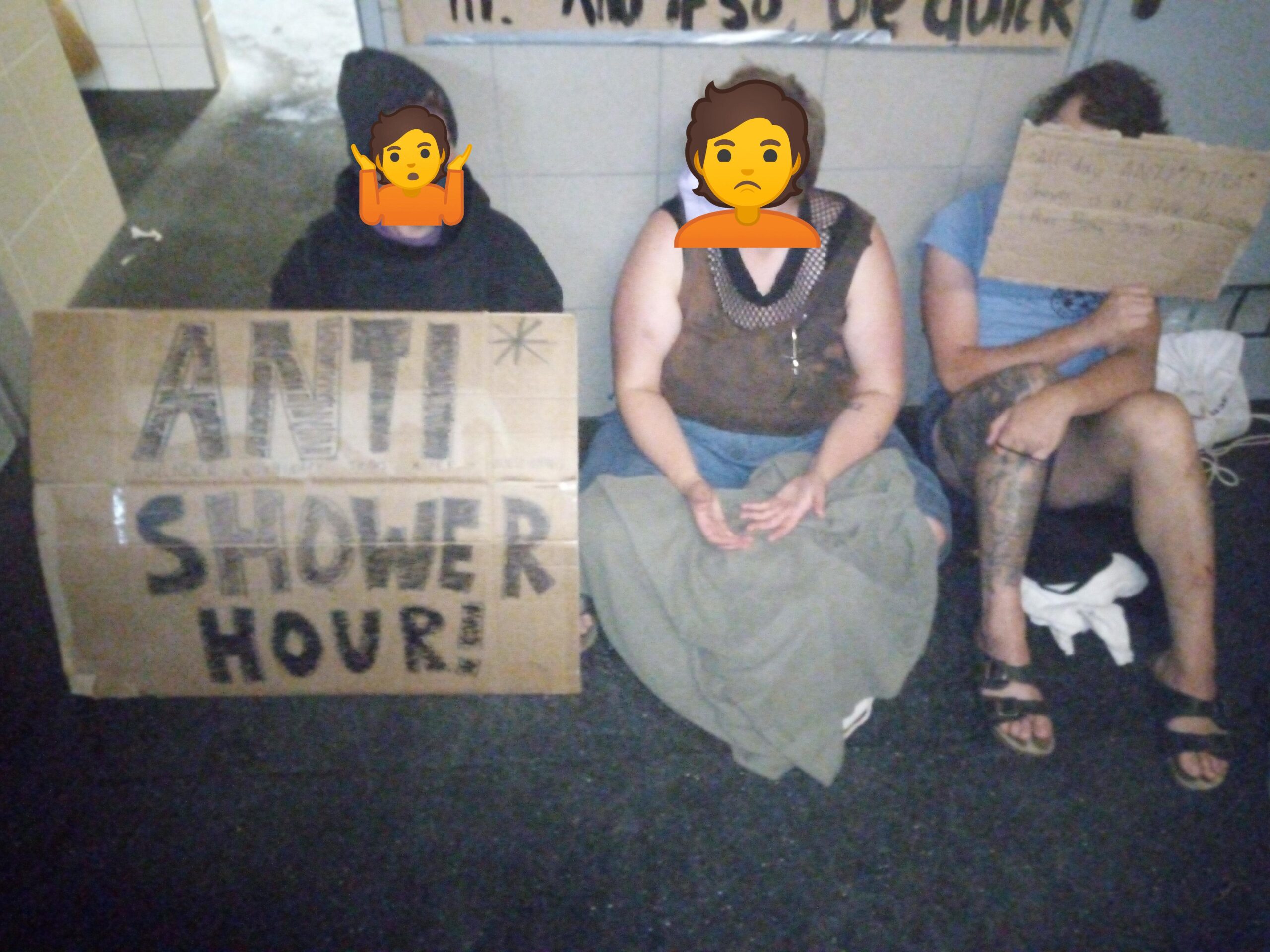 Menschen sitzen vor einer Gemeinschaftsdusche, mit einem Schild auf dem "Agender Trans Nonbinary Inter Shower Hour" steht.